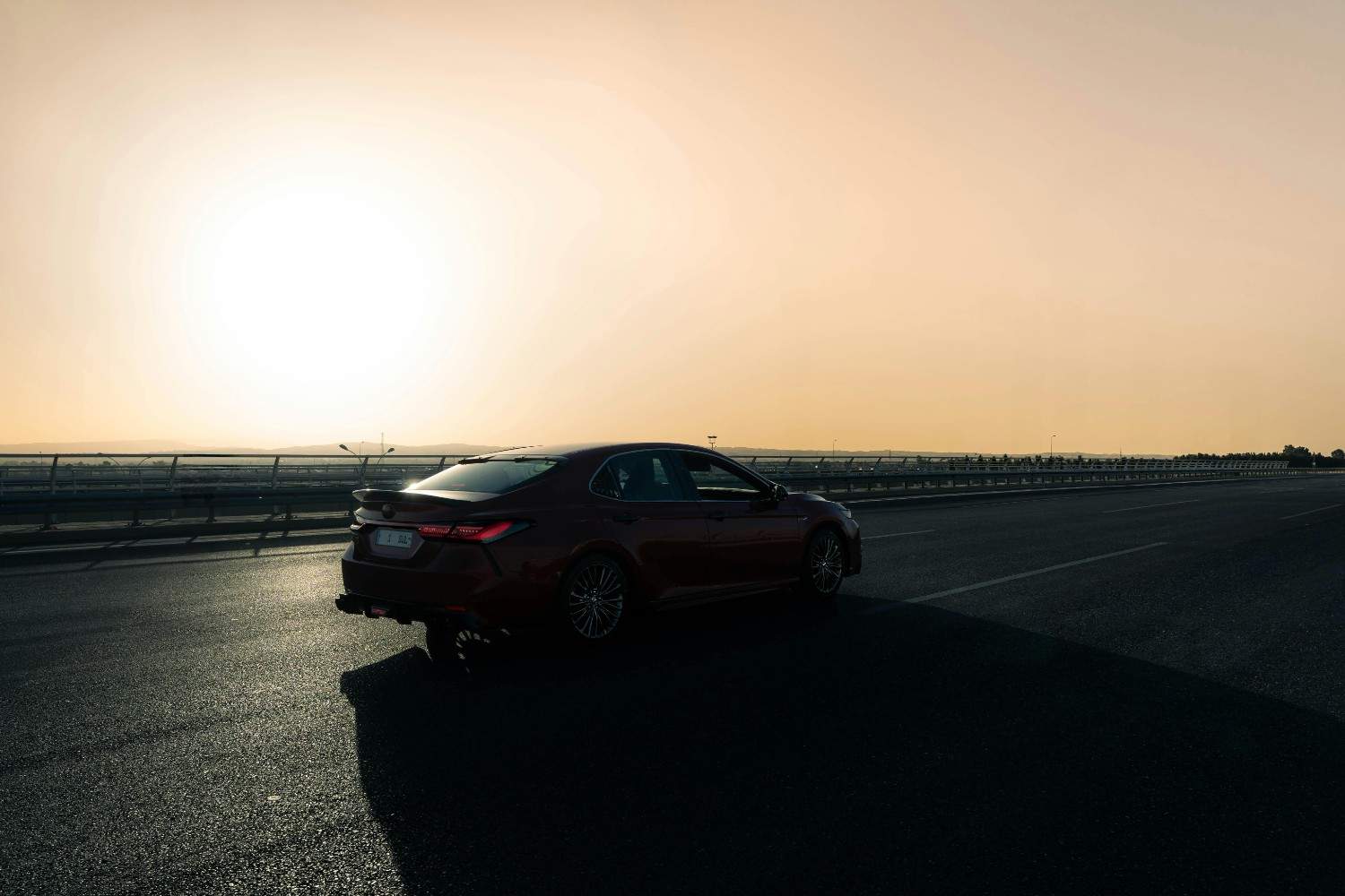 Modern car driving on a scenic highway at sunset